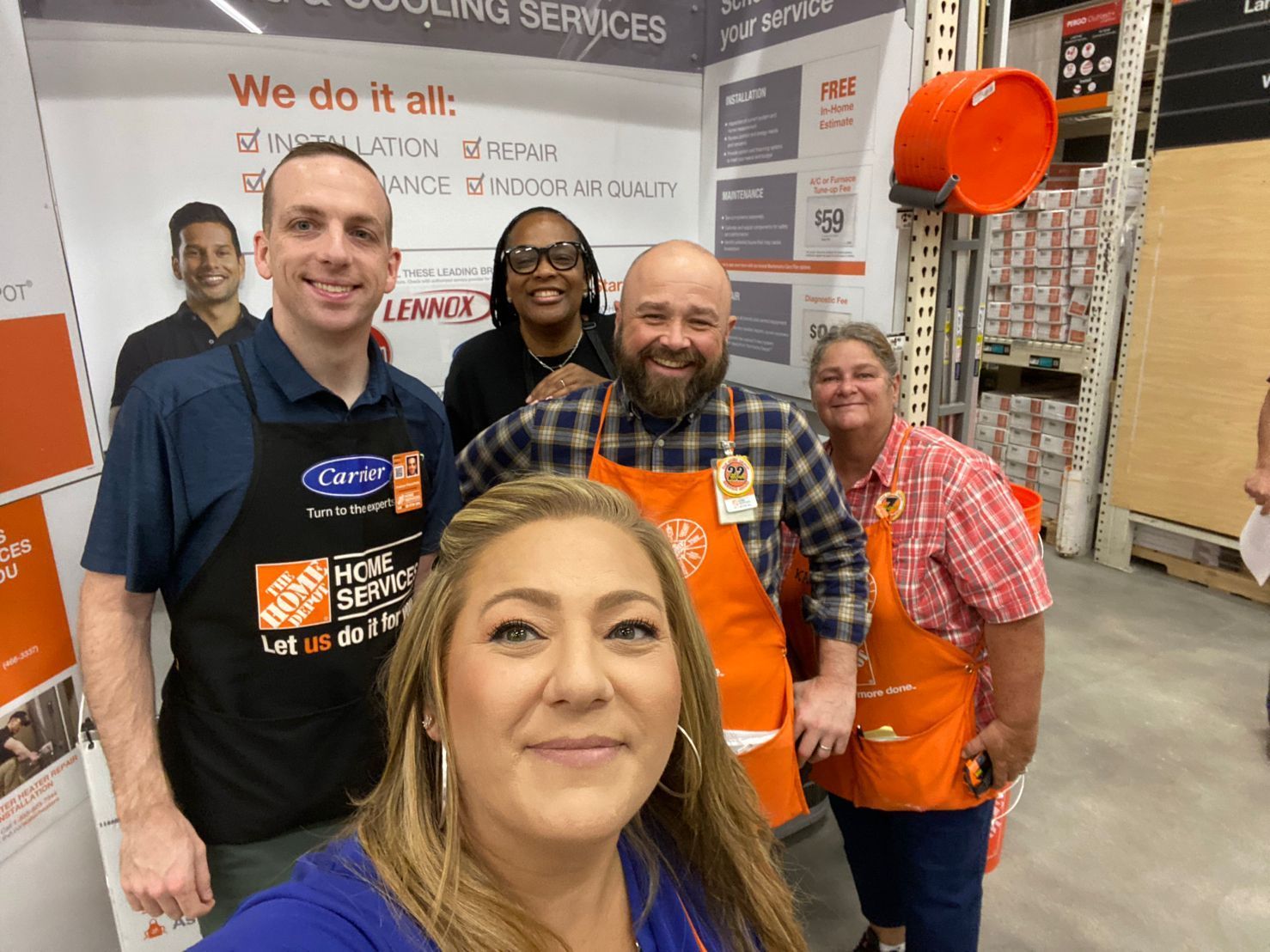 A group of Ebens Air Conditioning Employees standing in a Home Depot store talking to each other.