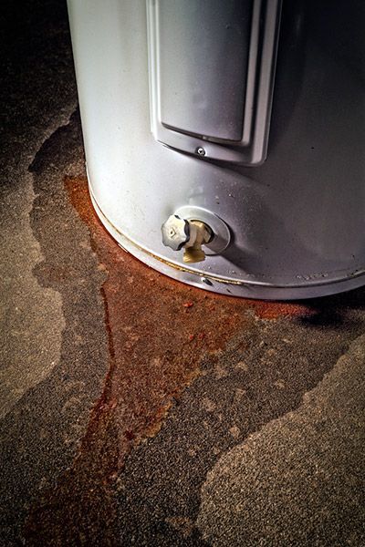 A water heater that is leaking water from the bottom