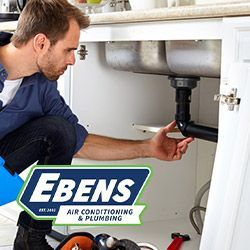 Plumber repairing a kitchen sink drain