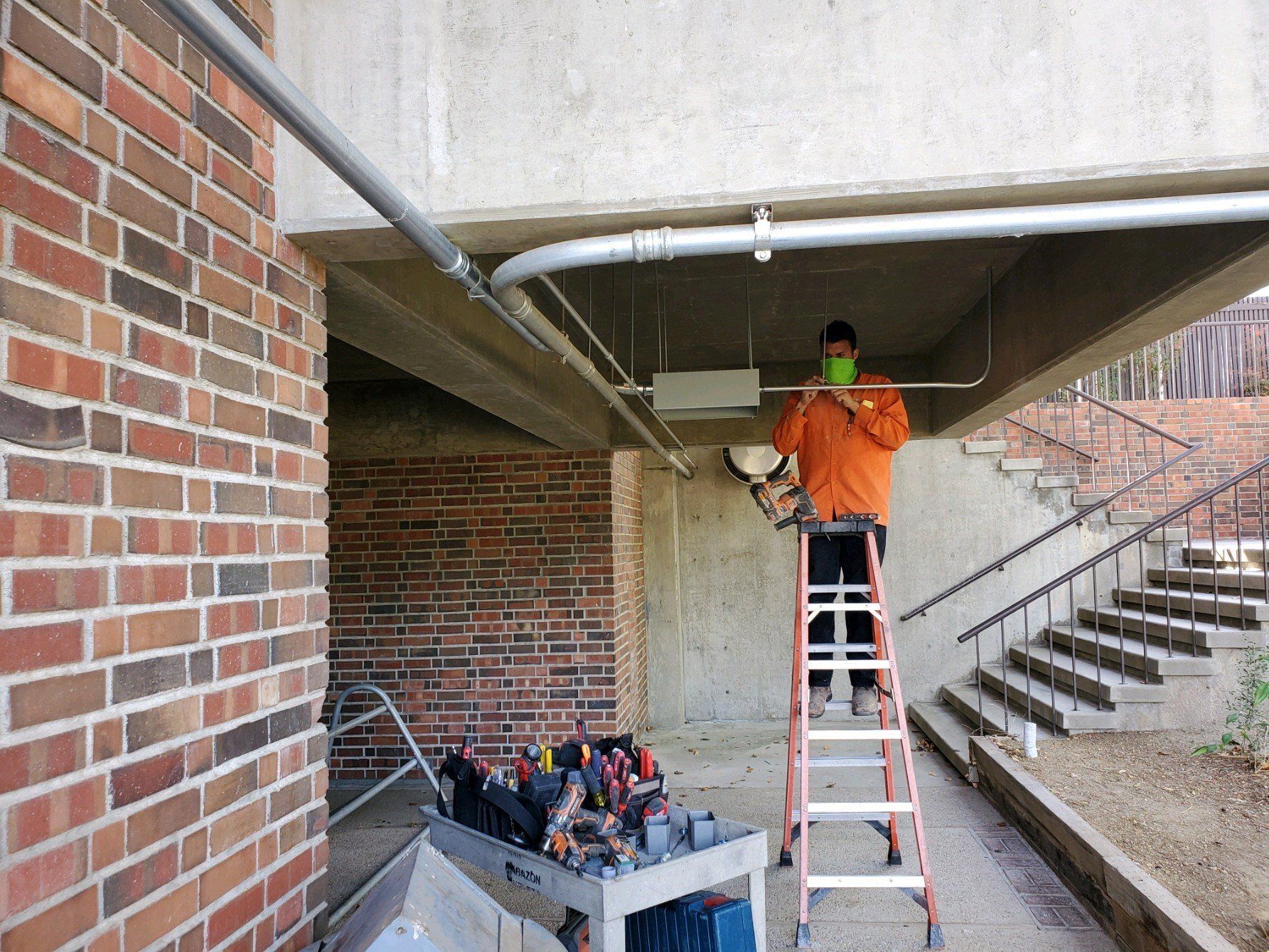 Worker on a ladder — Beaumont, CA — M. Brey Electric, Inc