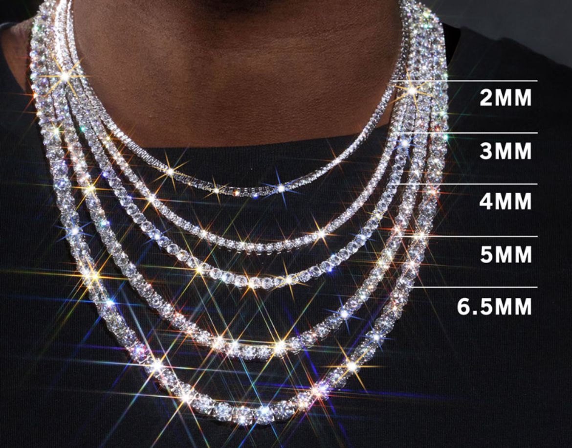Close-up of a person wearing multiple diamond tennis chain necklaces of varying thicknesses, with sizes labeled.