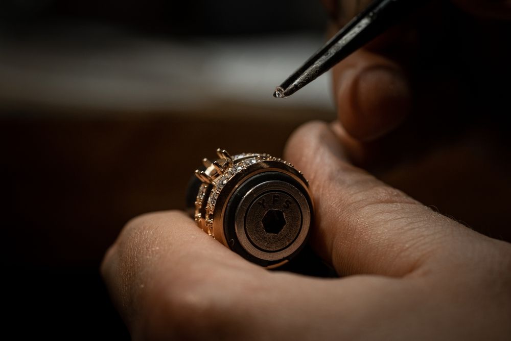 Gold ring with a diamond set in a white display case.