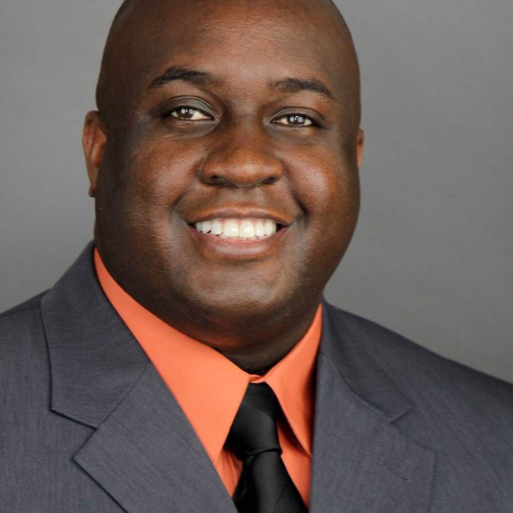 A man in a suit and tie smiles for the camera