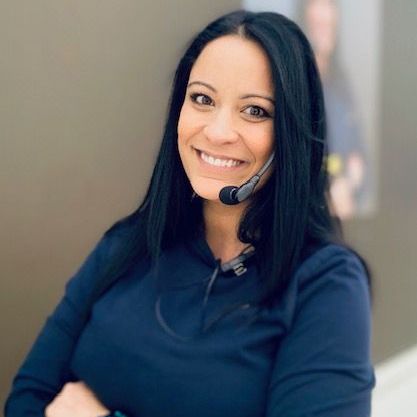 A woman wearing a headset is smiling for the camera.