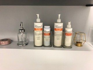 A shelf with bottles of lotion and soap on it.