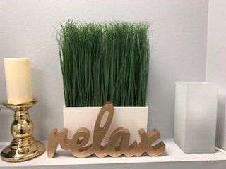A shelf with a candle and a sign that says relax