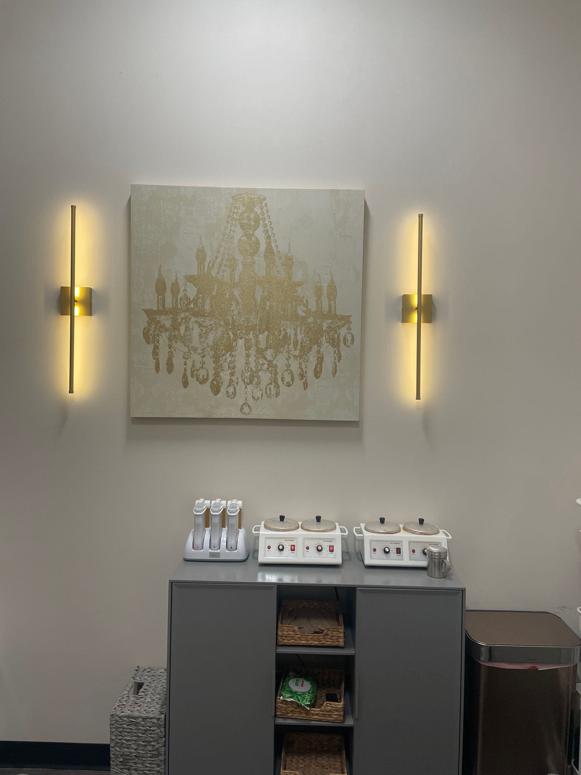 A room with a painting on the wall and two lights on the wall