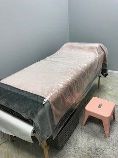 A bed with a pink stool next to it in a room.
