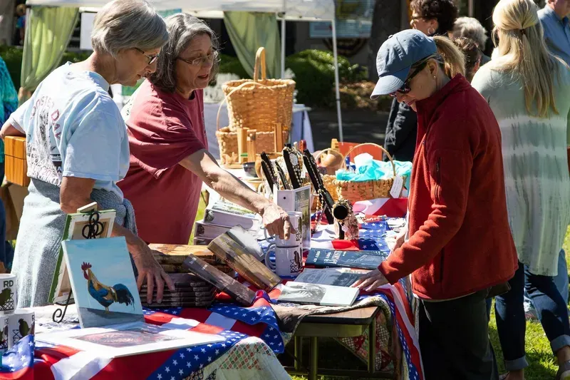 A group of people are standing around a table at a festival.