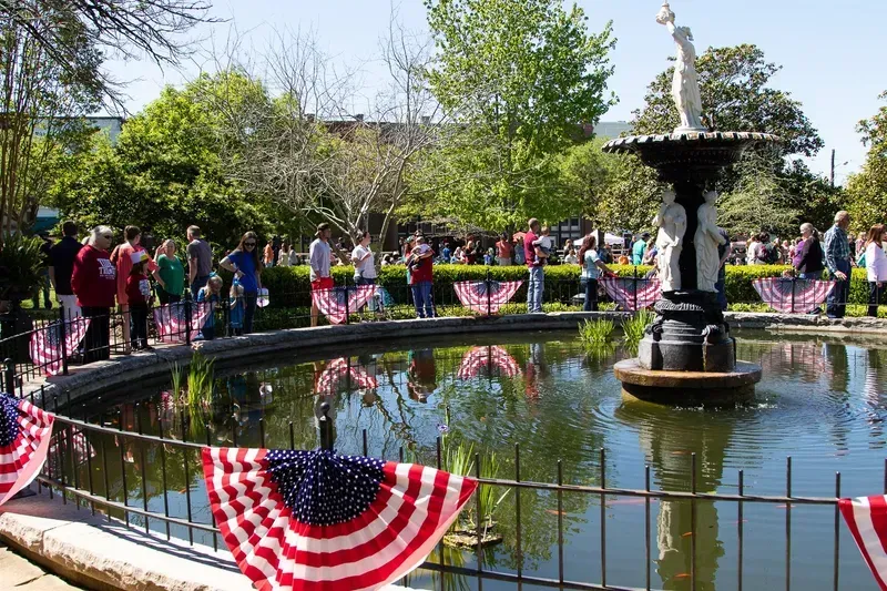 A fountain in a park with people standing around it