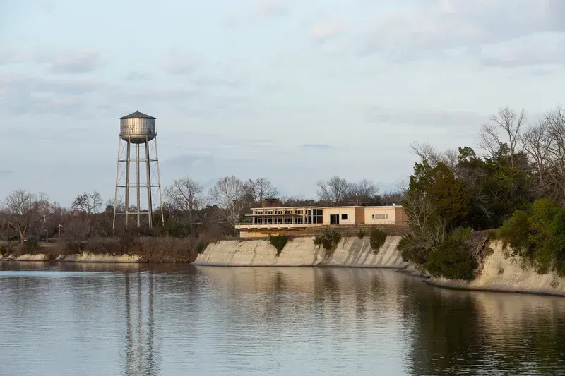 There is a water tower in the middle of a lake.