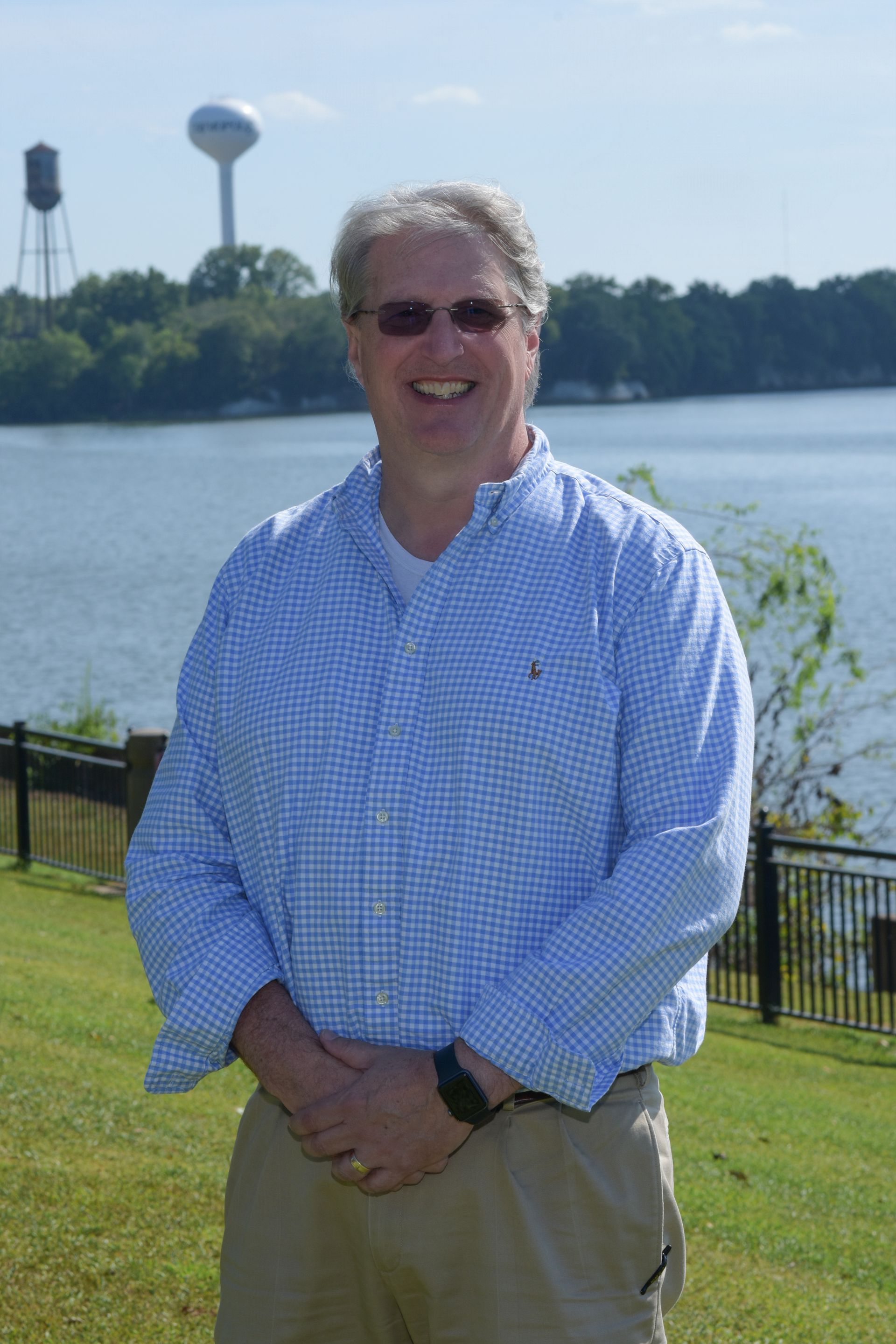 A man wearing glasses and a yellow shirt is posing for a picture.