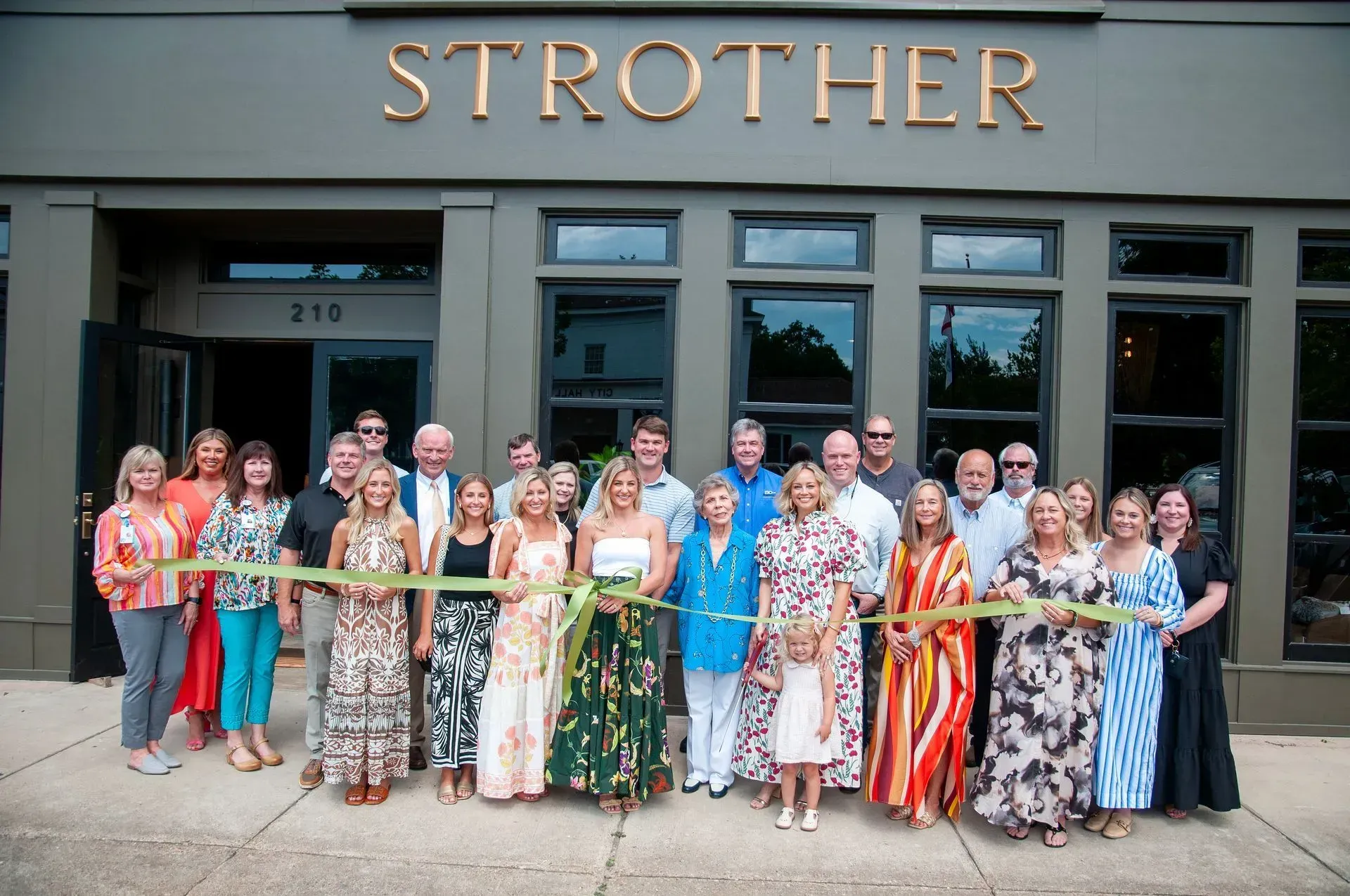 A group of people are standing in front of a strother building