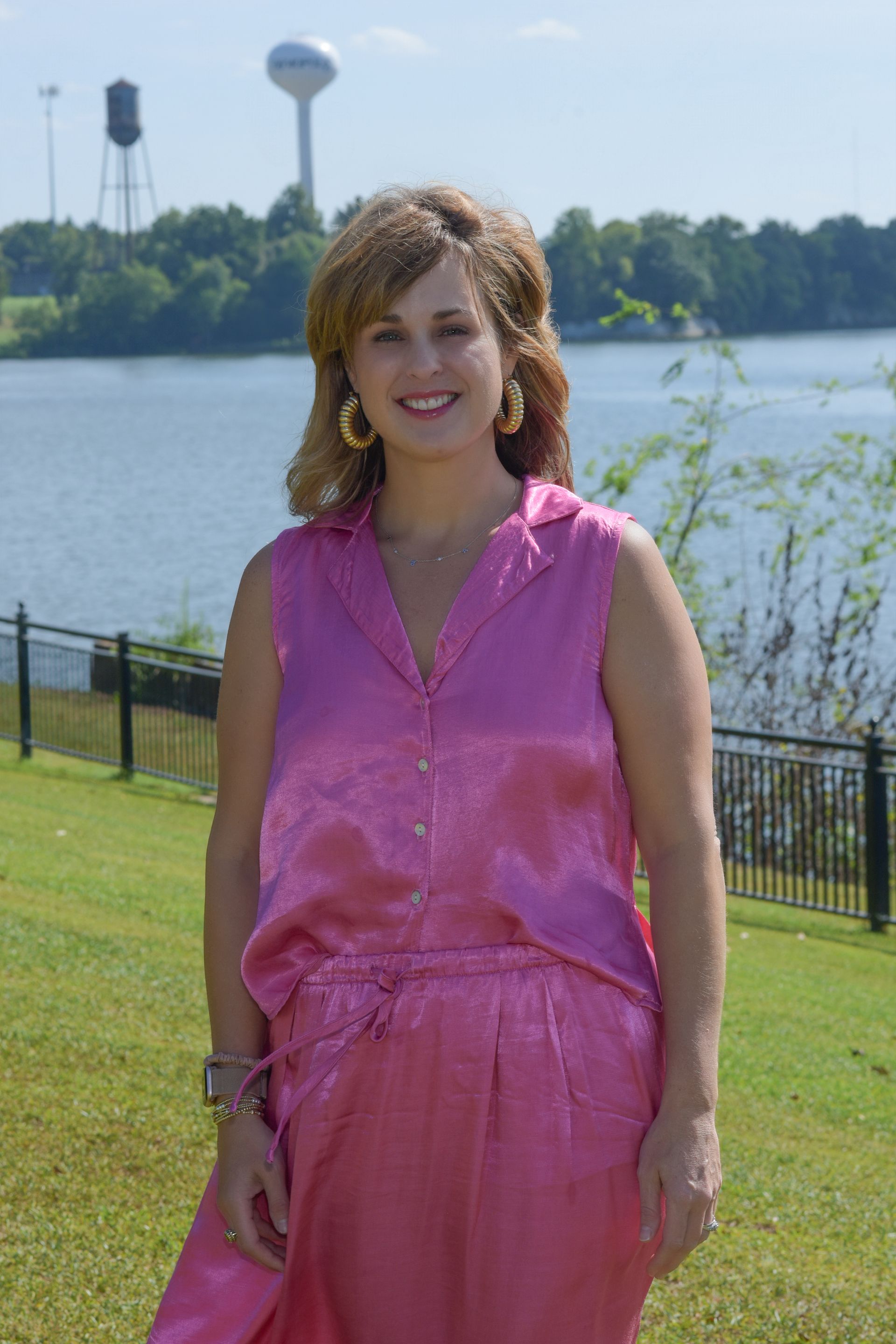 A woman in a blue shirt is smiling for the camera.