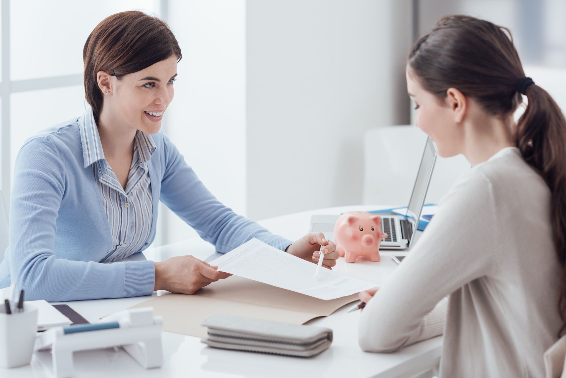 A woman is sitting at a table talking to another woman.