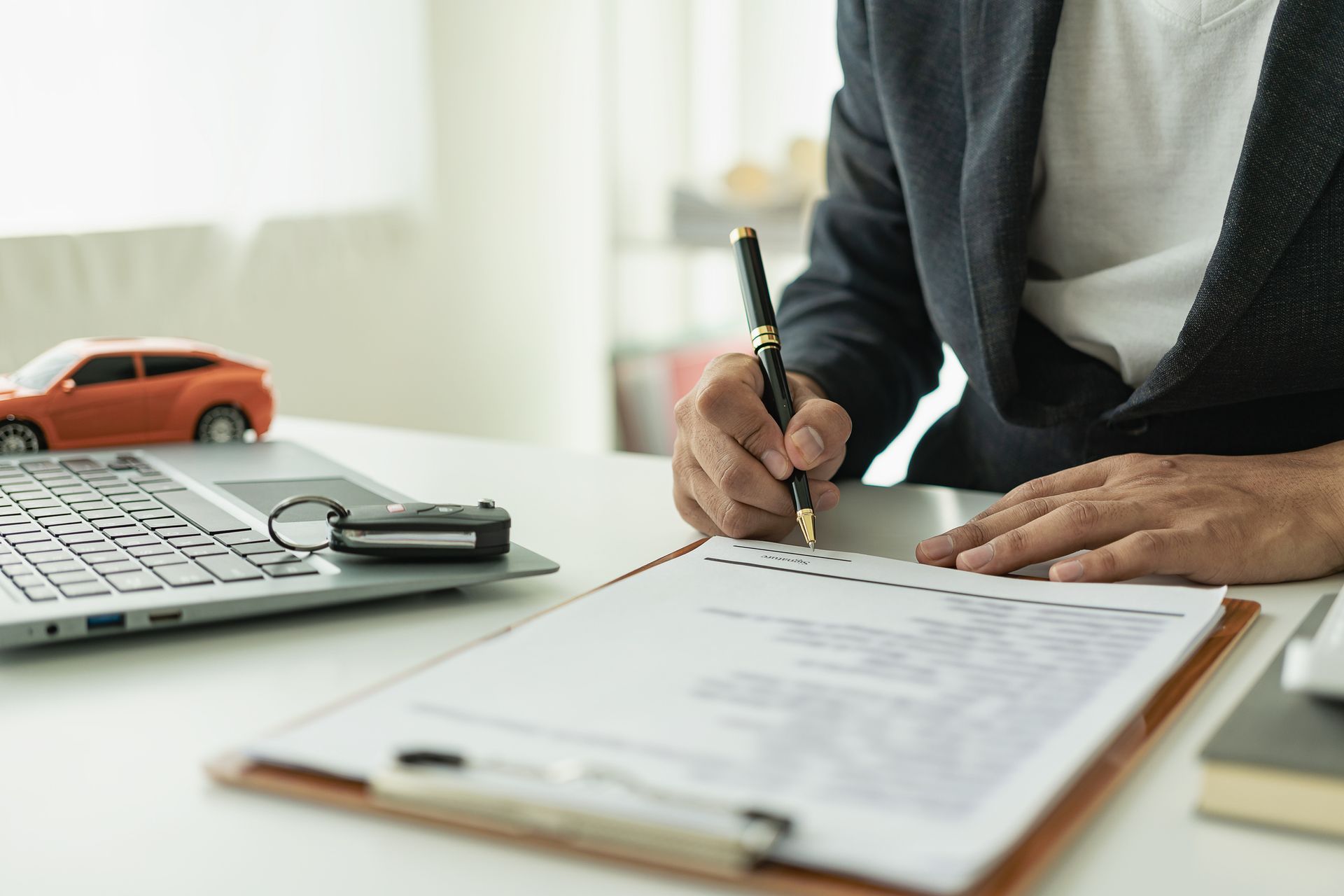 A man is sitting at a desk signing a document.
