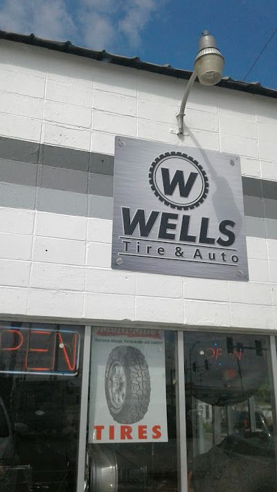 A white building with a sign that says wells tire & auto