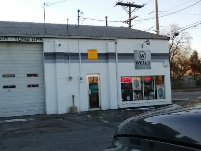 A white building with a sign that says wells on it
