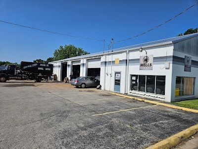 A car is parked in front of a large white building.