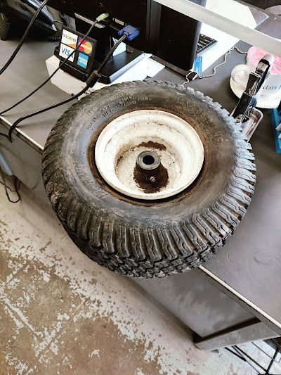 A tire is sitting on a table next to a computer.