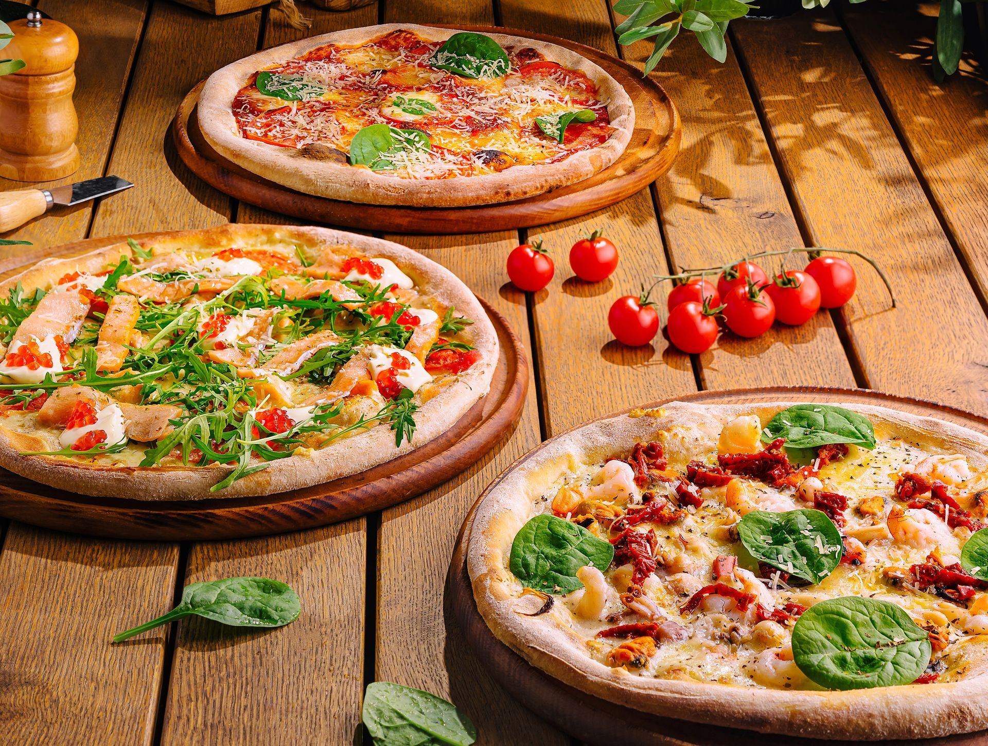 Three pizzas on wooden boards