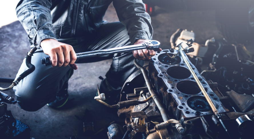 Mechanic working on an engine with a wrench in a garage.  | Rocky Mountain Car Care
