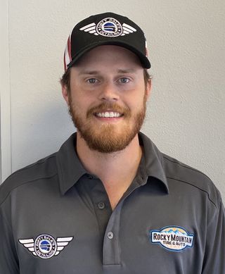 Man wearing cap and polo shirt with company logos, smiling.  | Rocky Mountain Car Care