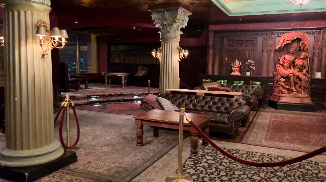 A large room with a couch , table , and columns.