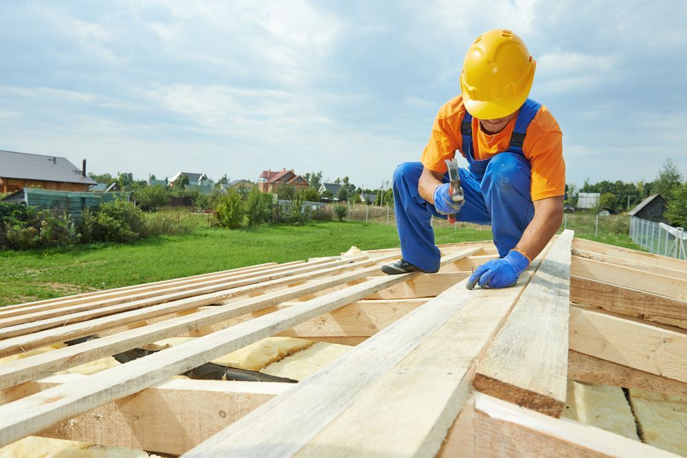 A construction worker is working on a wooden roof.