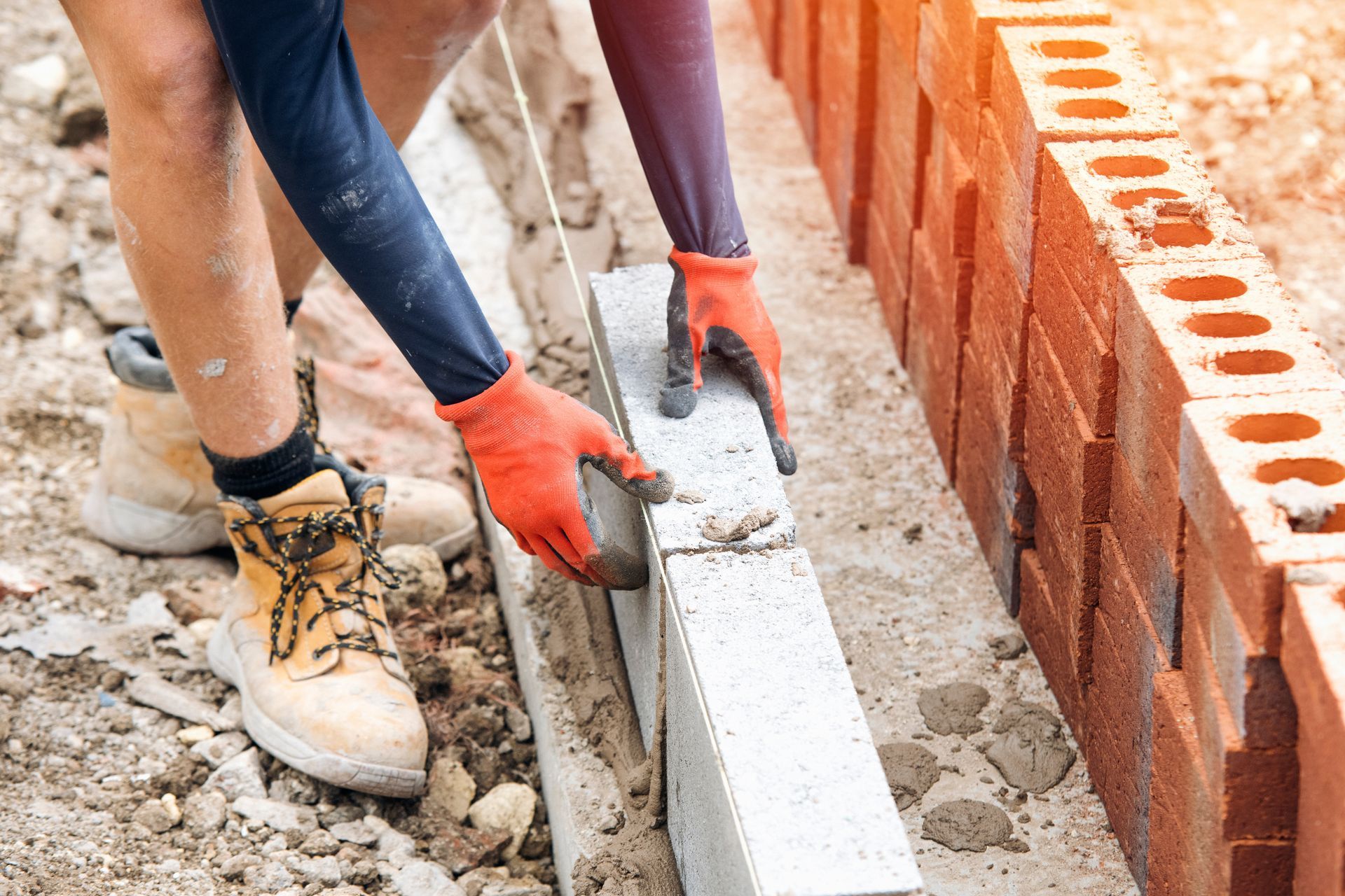 A man and a woman are building a brick wall.