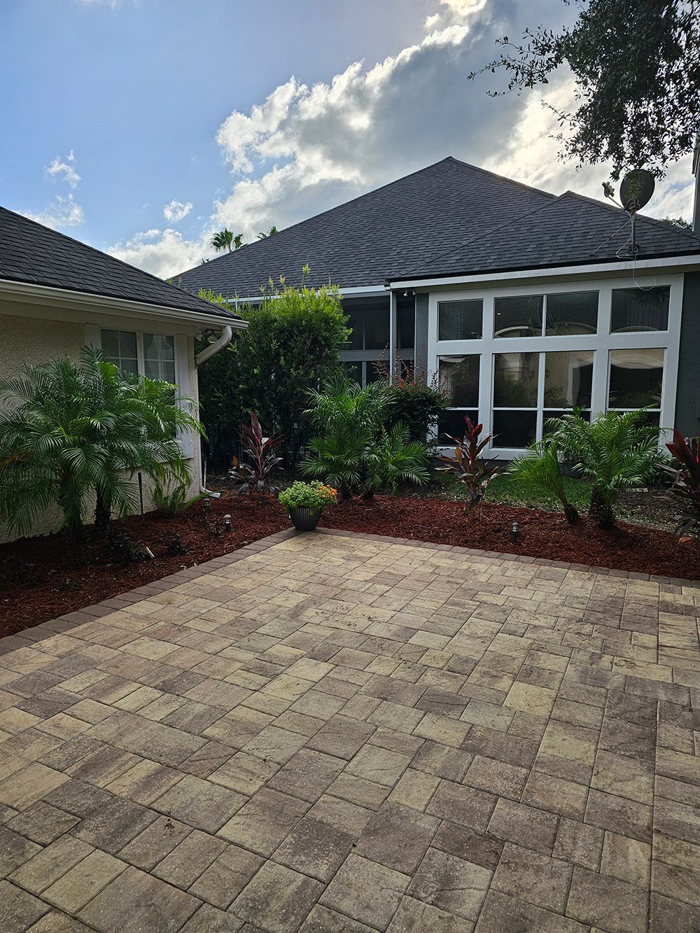A house with a brick driveway in front of it.