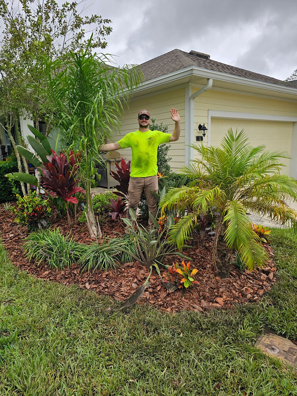 A man is standing in front of a house in a garden.