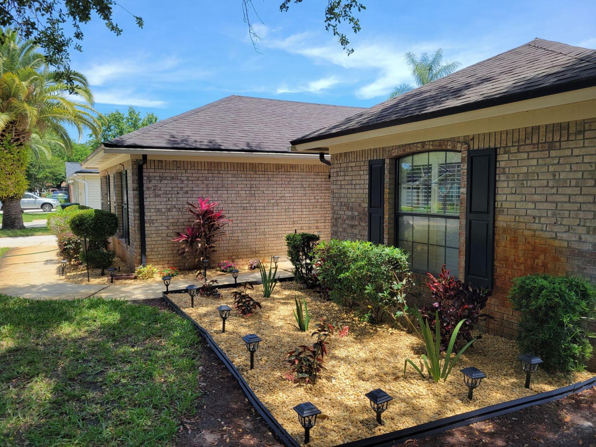 A brick house with a garden in front of it.