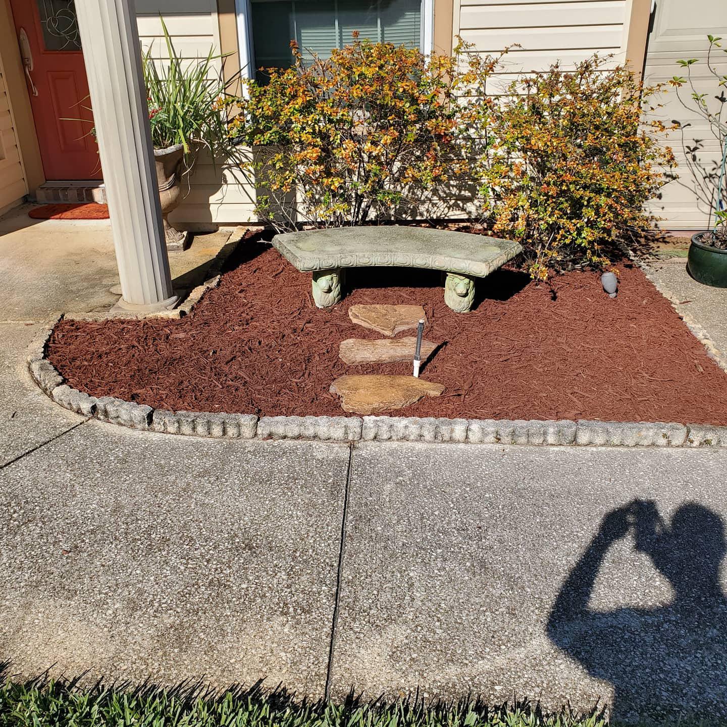 A stone bench is sitting in a garden next to a house.