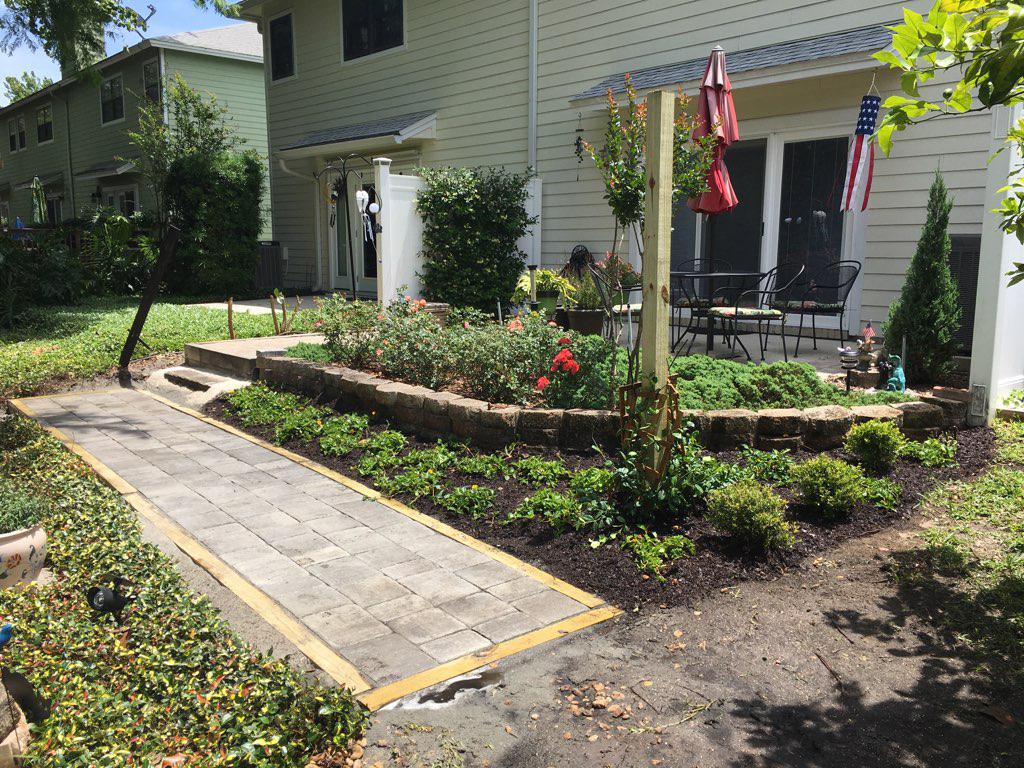 A house with a patio and a walkway in front of it.
