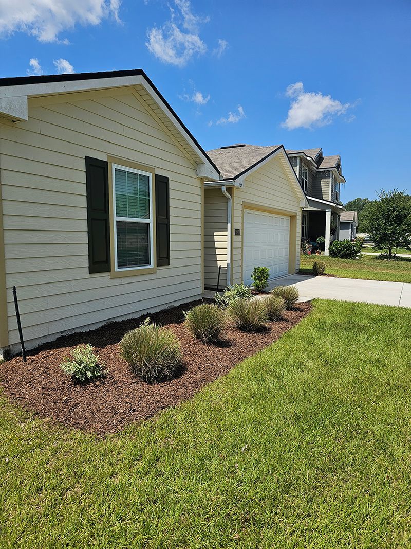 A house with a garage and a lot of grass in front of it.