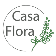 Logotipo da Casa Flora: texto cinza dentro de um círculo com a ilustração de uma planta verde.