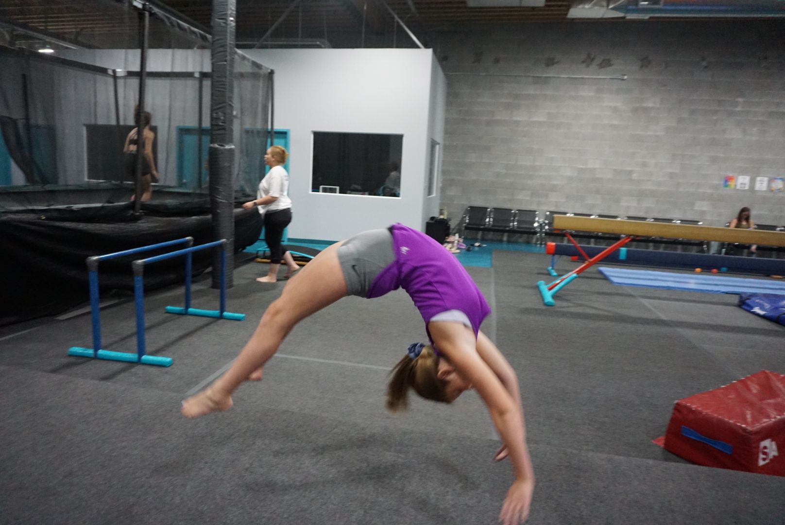 A girl is doing a handstand in a gym
