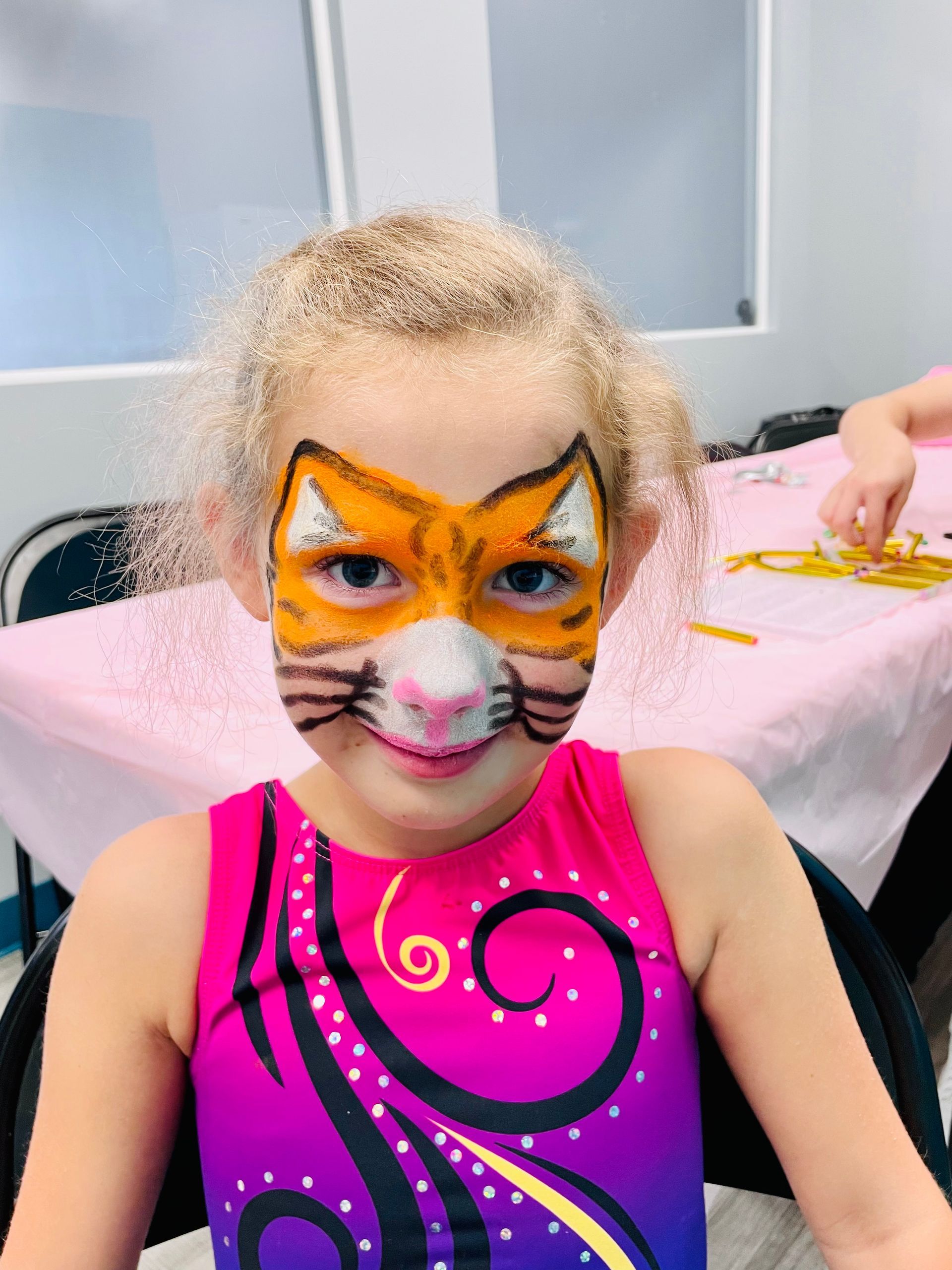 A little girl with her face painted like a cat