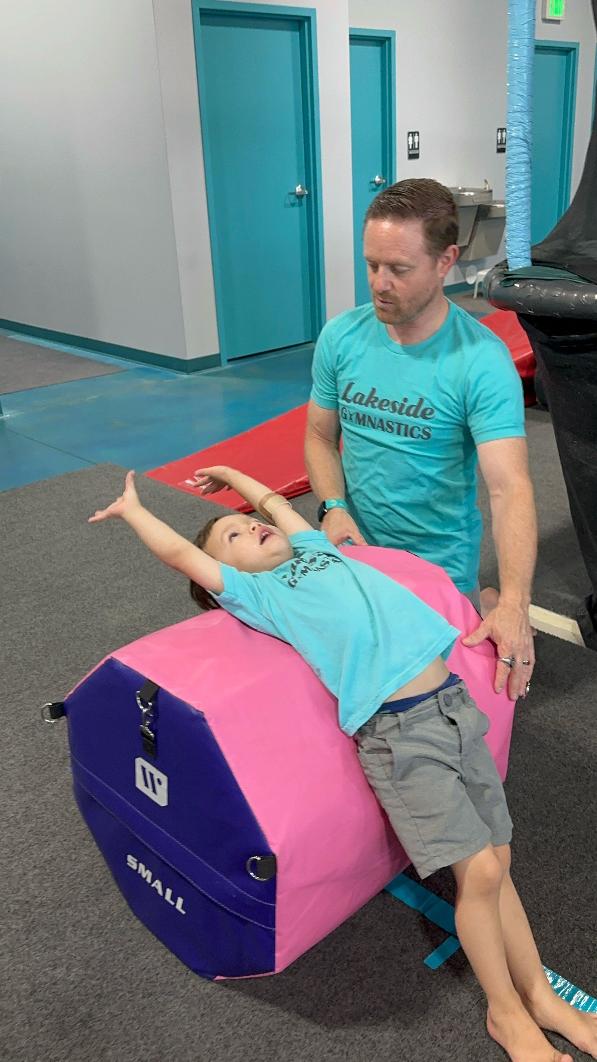 A group of children are dancing in front of a mirror in a dance studio.