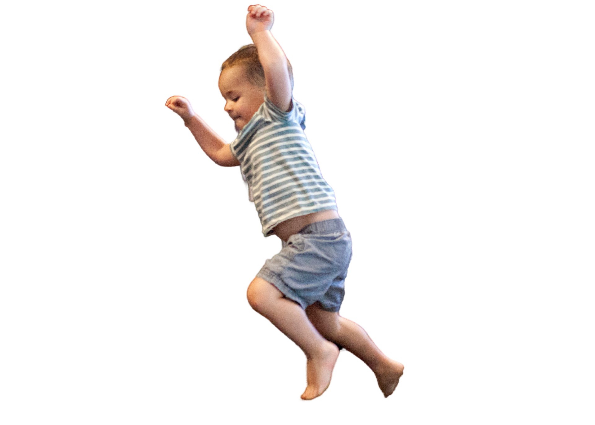 A little boy is jumping in the air with his arms in the air.