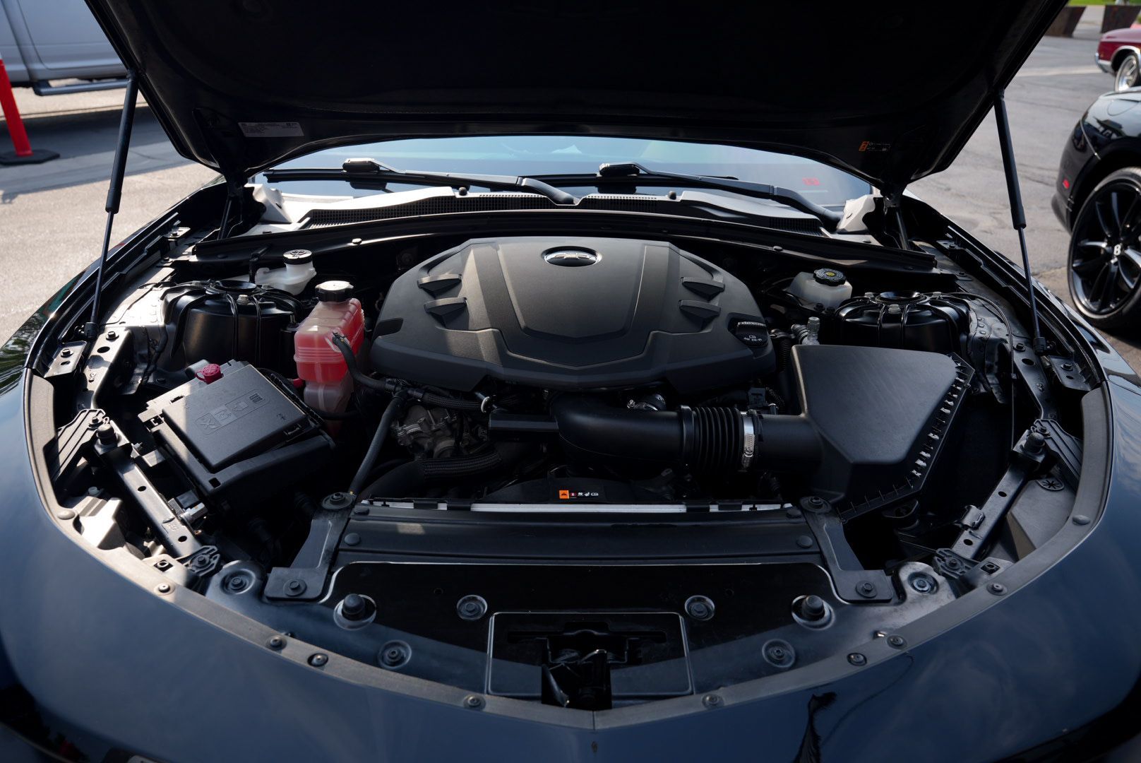 Black car engine bay with the hood open.