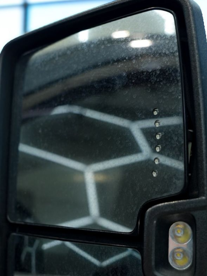 Side view mirror on a vehicle, with a blind spot indicator and LED light.