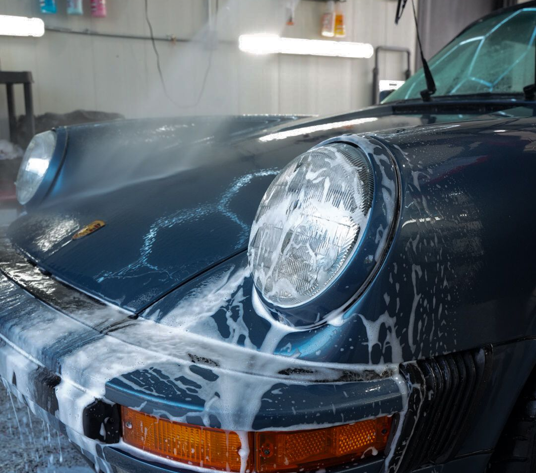 A close up of water drops on the hood of a car