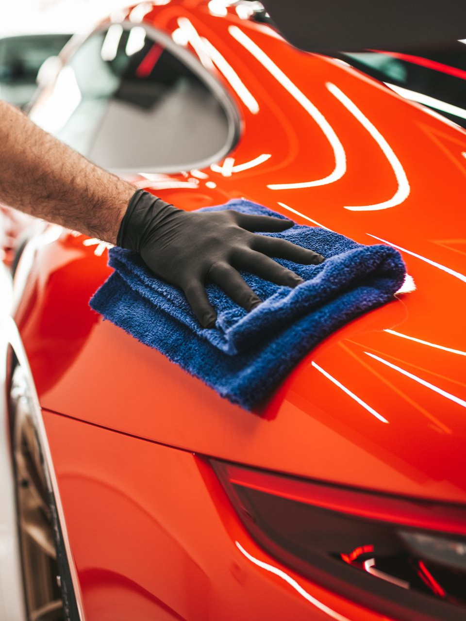 Orange McLaren sports car with doors open, parked outdoors.