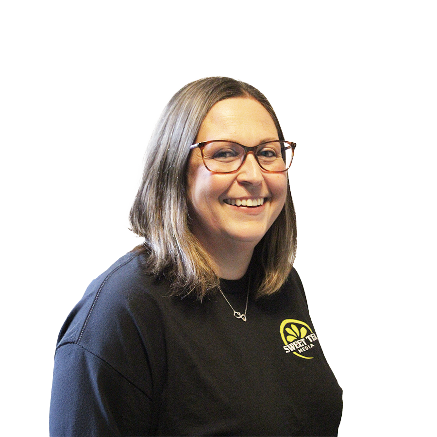 A woman wearing glasses and a black shirt is smiling.