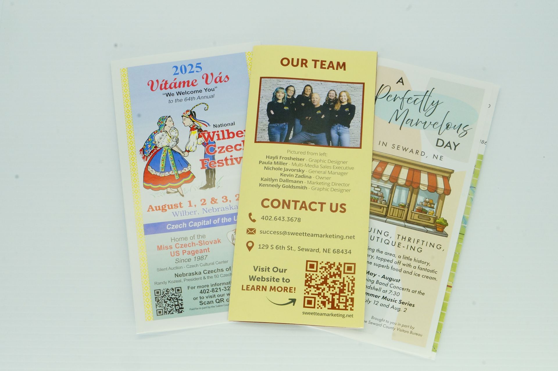 Three brochures with one that says contact us on it