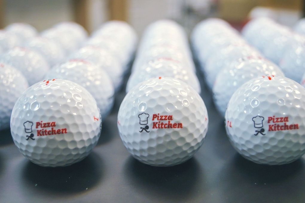A bunch of golf balls with pizza kitchen written on them