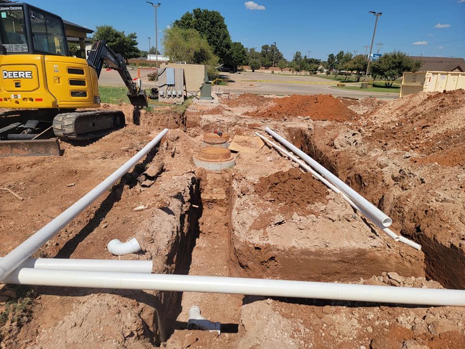 A yellow excavator is digging a hole in the dirt
