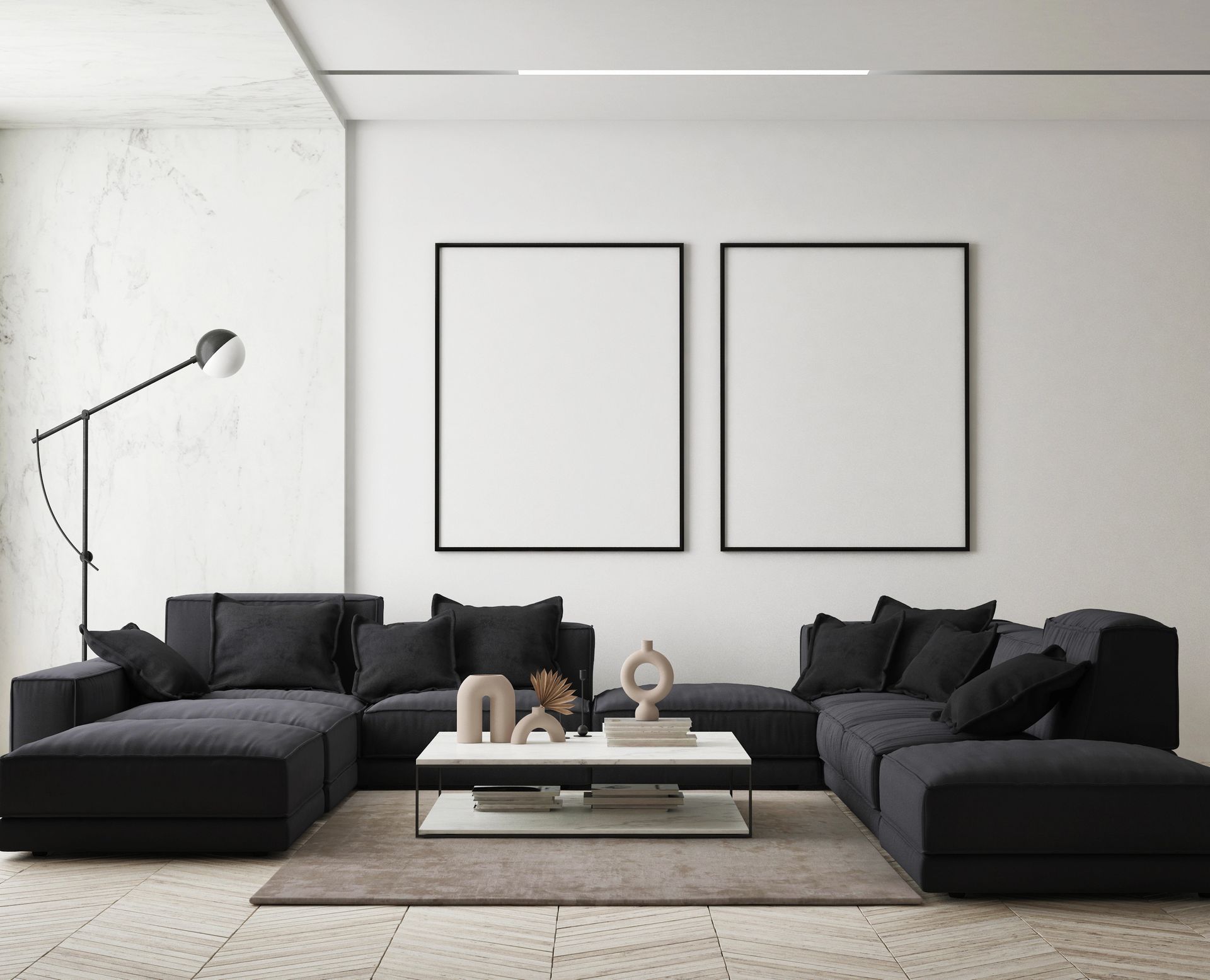 Soggiorno moderno con divano componibile nero, quadri con cornice vuota e oggetti decorativi.